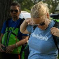 three women putting on life jackets outside